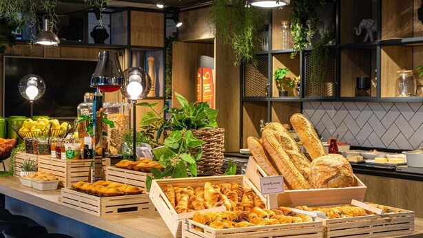 Un bufé de desayuno con diversos pasteles, pan y bebidas.