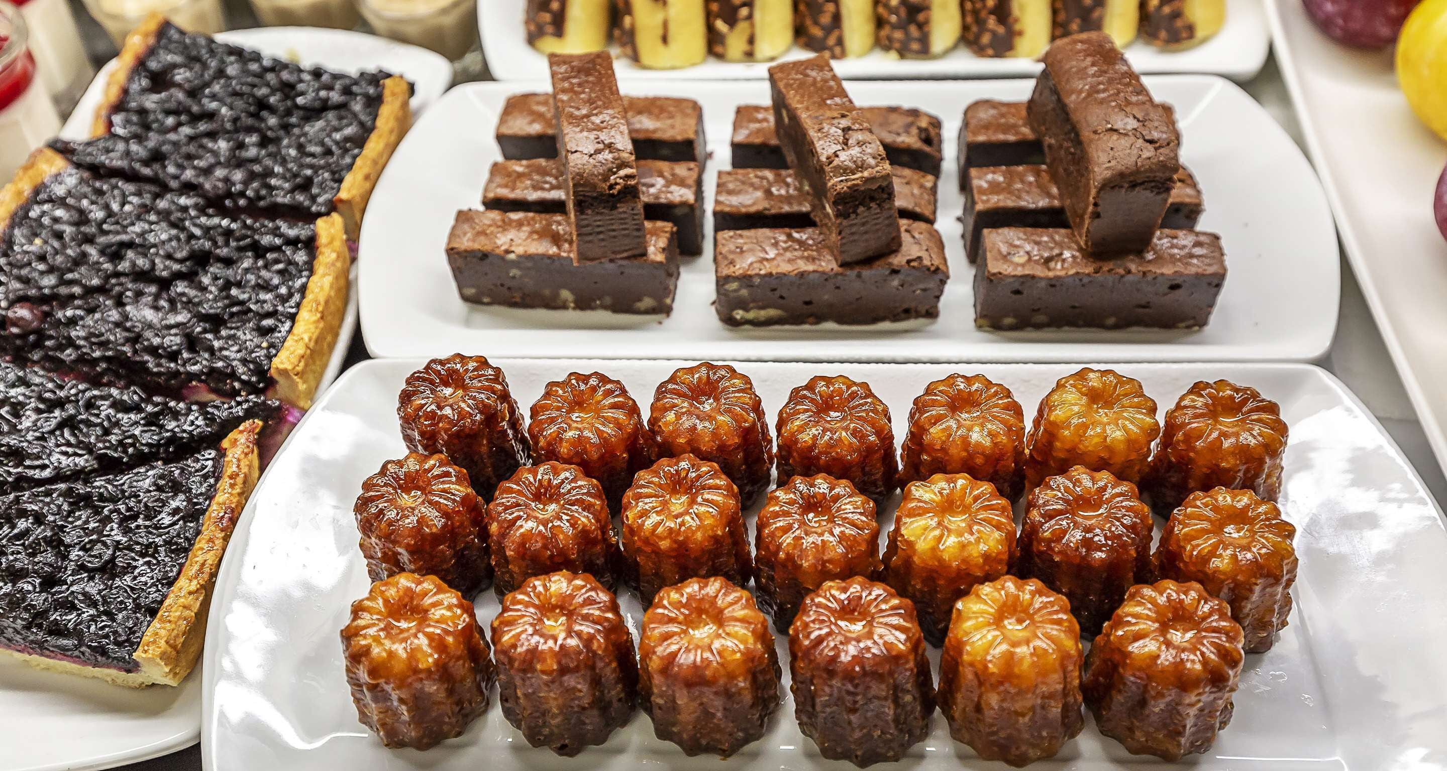 A variety of desserts including a tart, brownies, and glazed pastries.