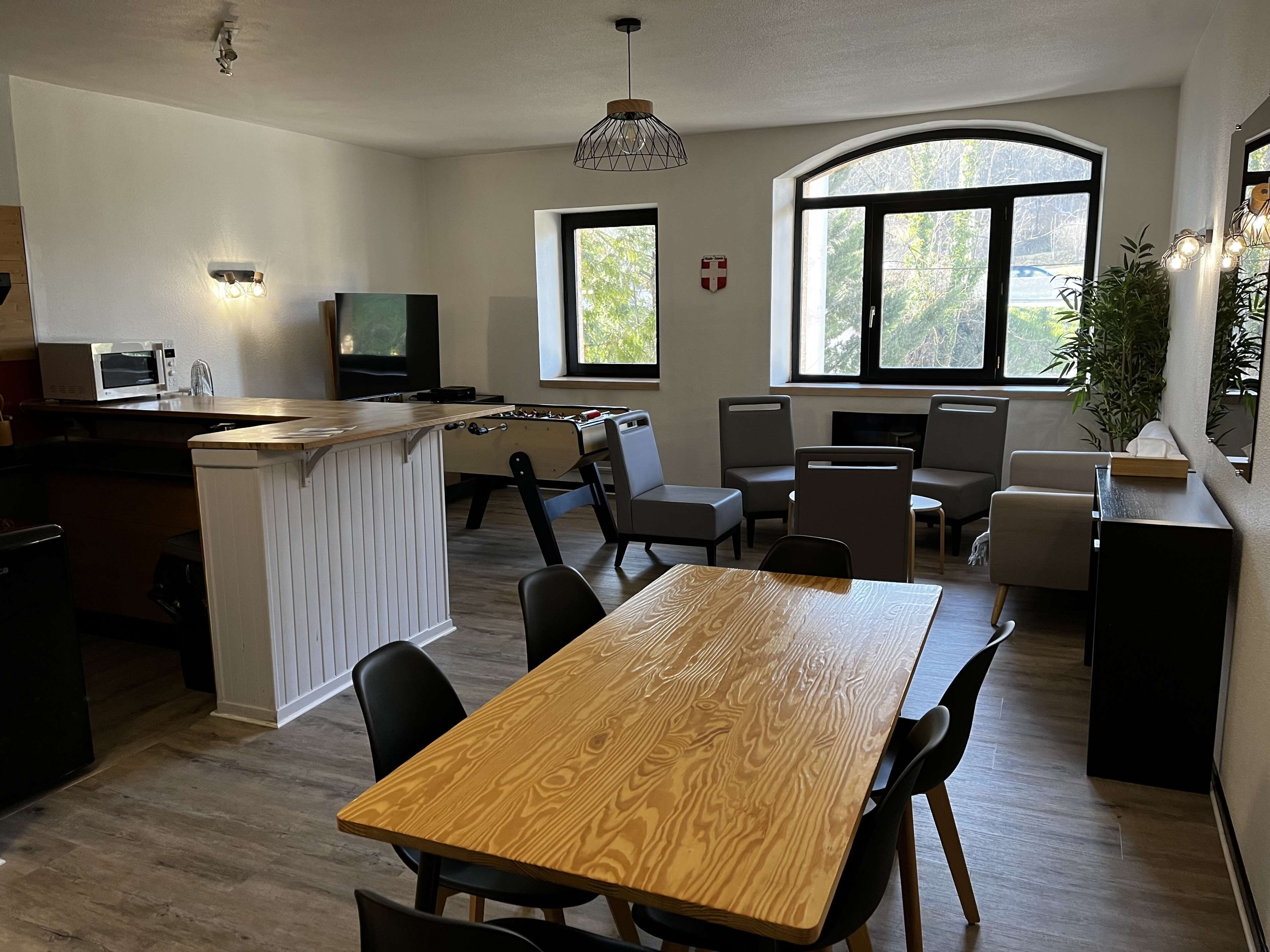 Een moderne keuken met een centraal eiland, een eethoek met een houten tafel en stoelen, en een zithoek met banken.