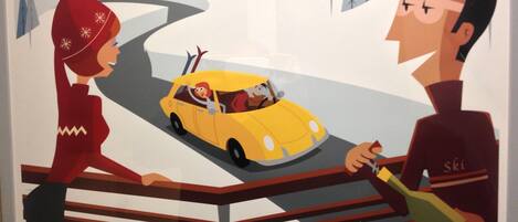 Una ilustración estilizada de un hombre y una mujer sentados a una mesa con una botella y vasos, con un coche amarillo circulando por una carretera al fondo.