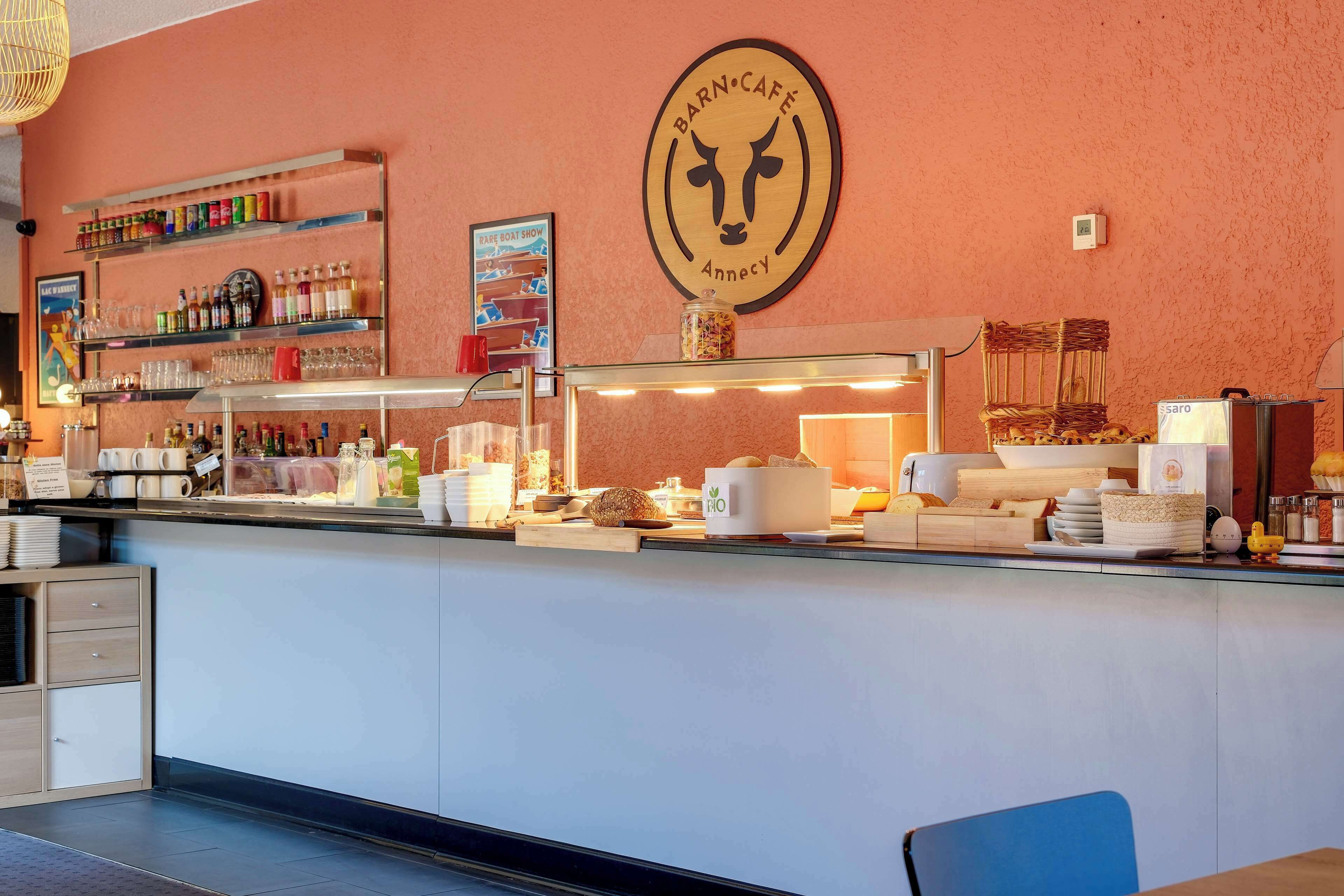 A counter with a variety of food and drink items, a logo on the wall, and a sign for a boat show.