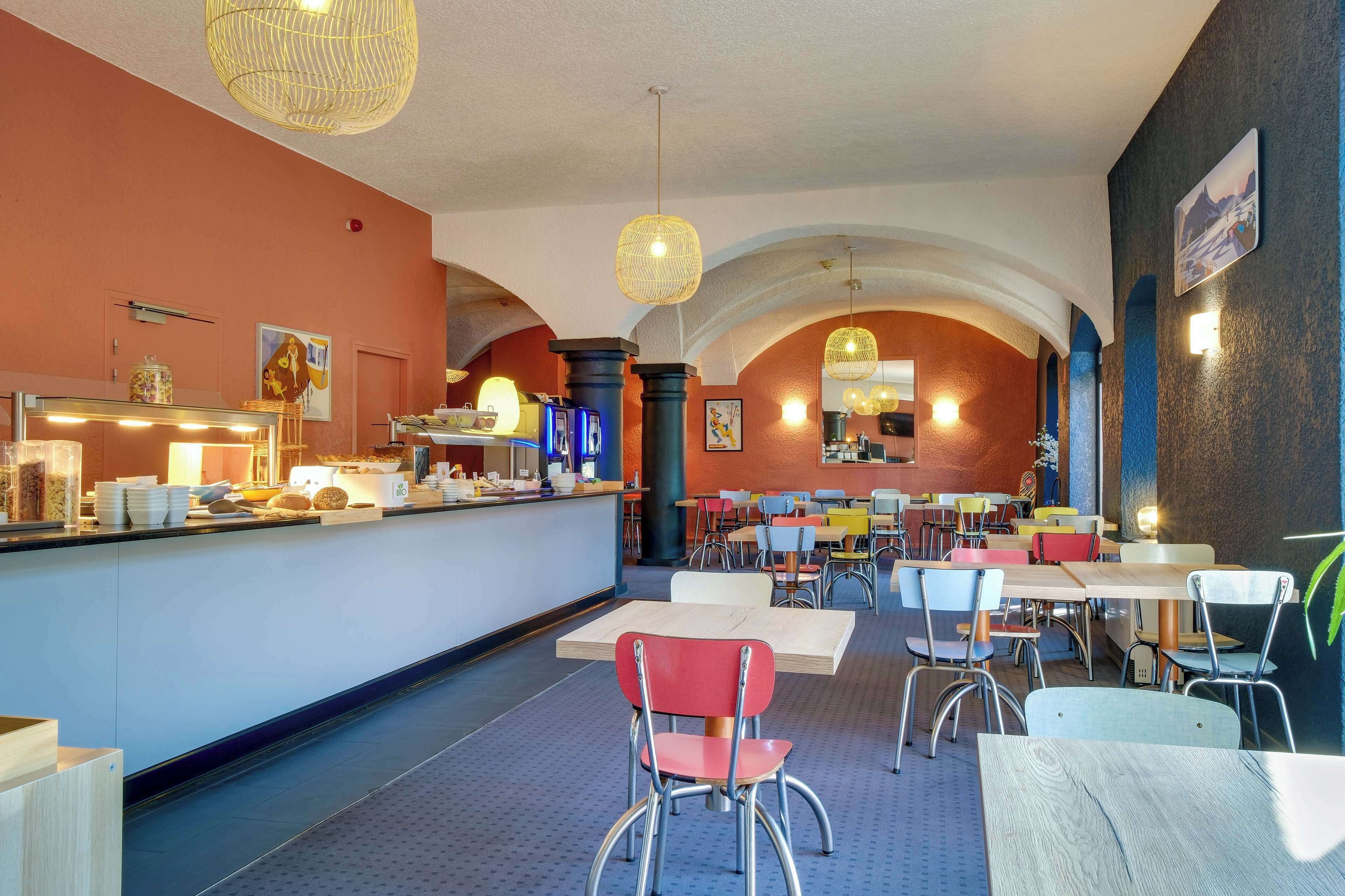 A restaurant with a bar area, tables, and chairs.