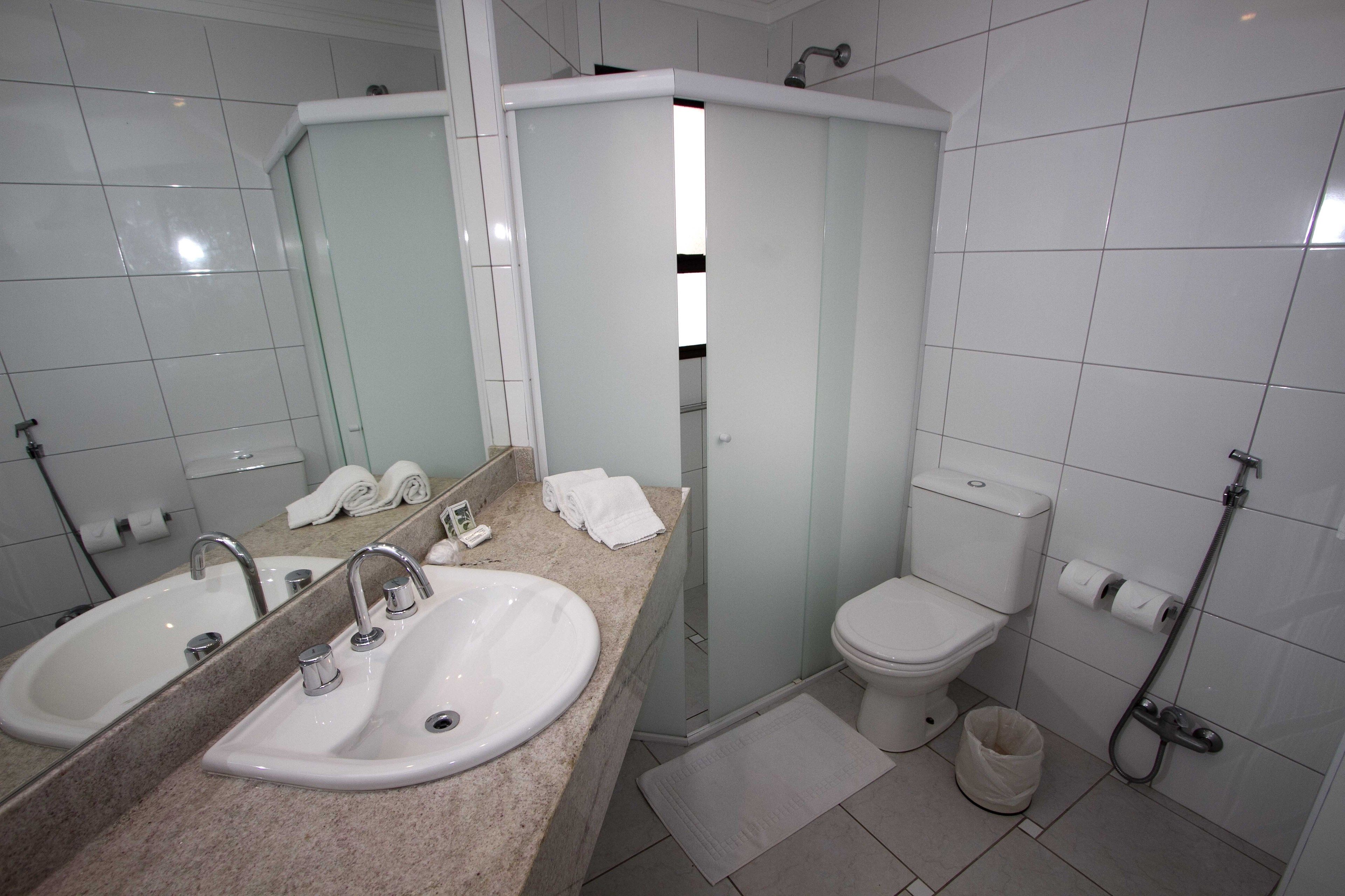 Un baño con dos lavamanos, un inodoro y una ducha.
