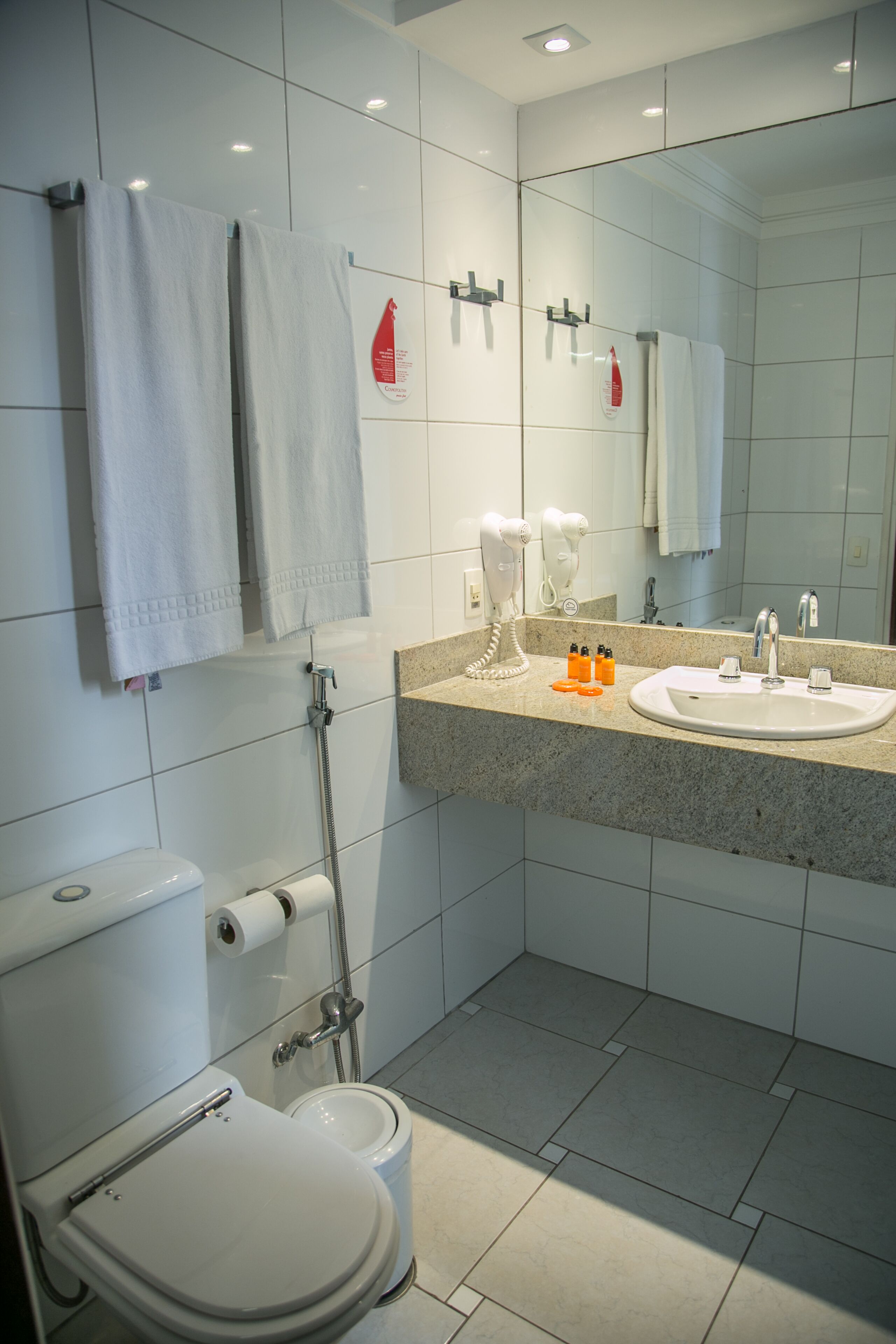 A modern bathroom with a toilet, bidet, and sink.