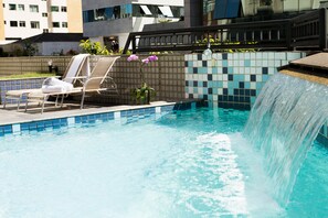 Alberca al aire libre, sombrillas en la alberca y camastros 