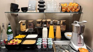A breakfast buffet with various food options, including fruits, cereals, and beverages.
