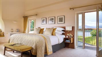 A bedroom with a bed, a bench, a nightstand, a window with a view, and a door.
