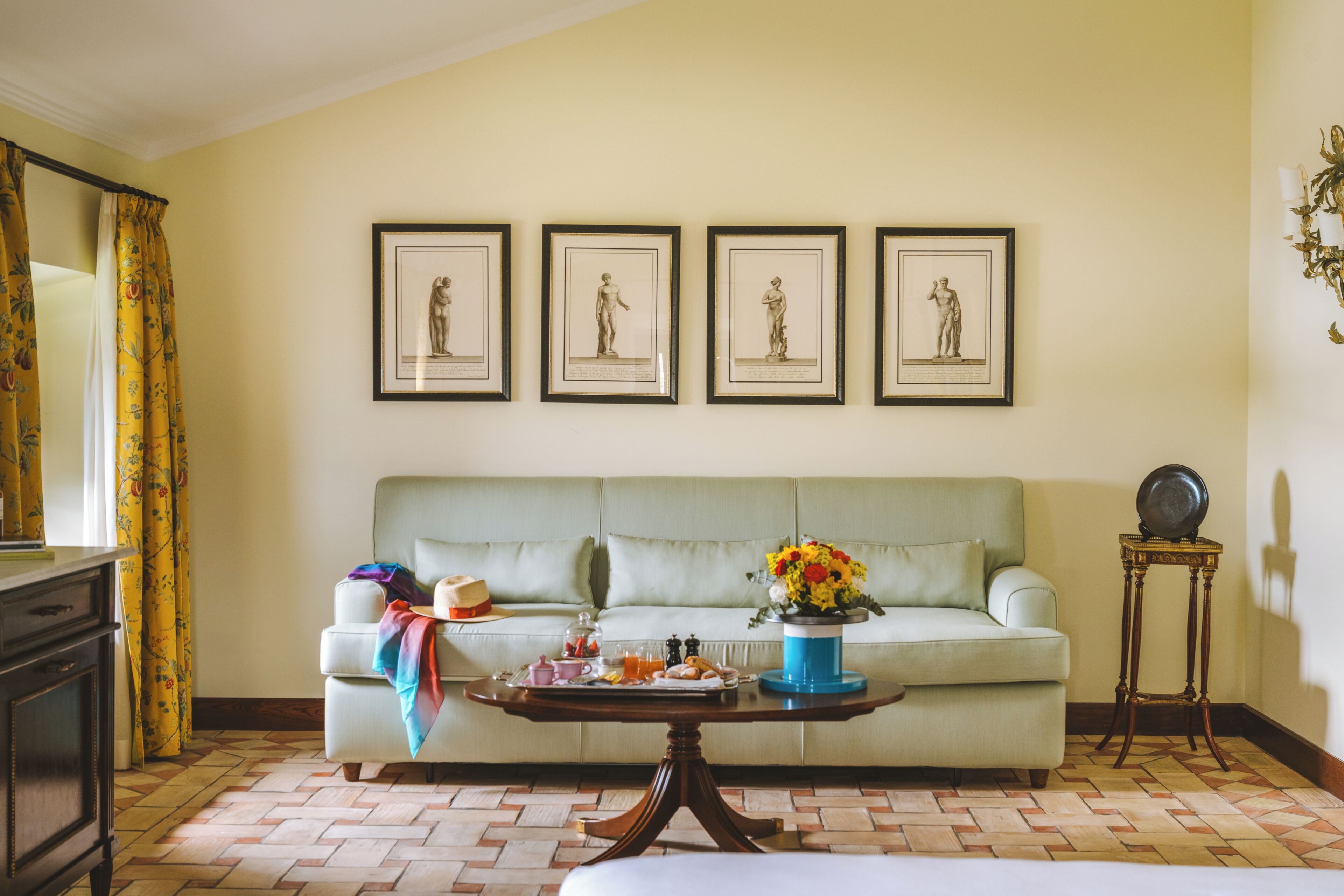 Une pièce comprenant un canapé, une table basse, une commode et des tableaux encadrés accrochés au mur.
