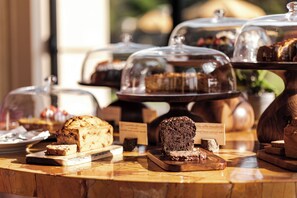 A bakery display with various breads and pastries under glass domes. - La Posta Vecchia Hotel (Ladispoli)