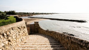 A stone staircase leading to a beach with a view of the ocean. - La Posta Vecchia Hotel (Ladispoli)