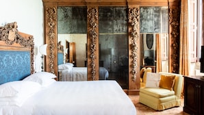 A bedroom with a large bed, a sofa, a wardrobe, and a mirror. - La Posta Vecchia Hotel (Ladispoli)
