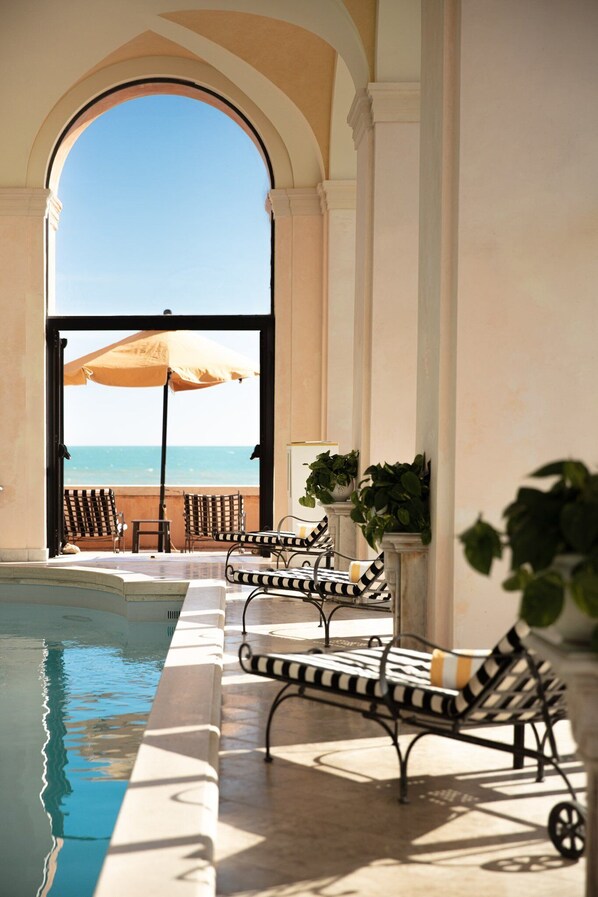 Piscine intérieure, parasols, chaises longues