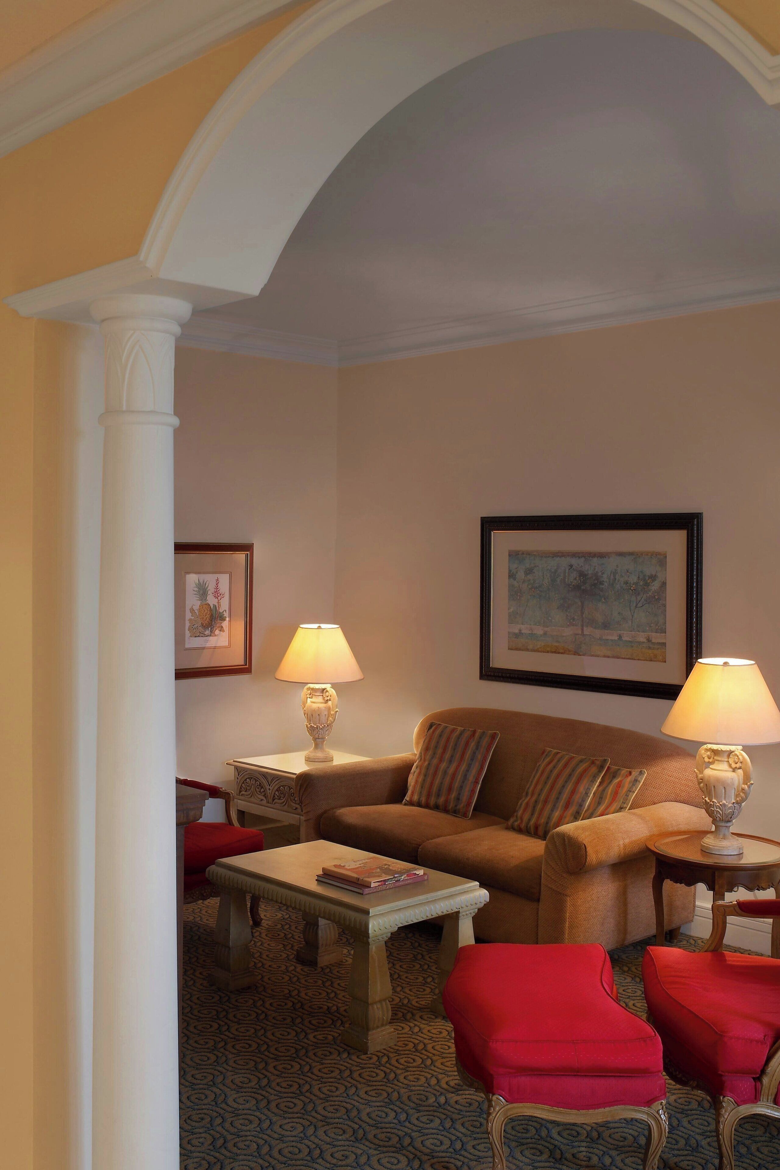 A living room with a sofa, two armchairs, a coffee table, and two lamps.