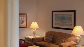 A living room with a sofa, two armchairs, a coffee table, and two lamps.