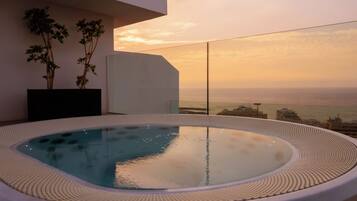 Un jacuzzi con vistas despejadas al paisaje urbano al atardecer.