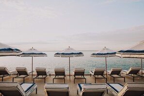 On the beach, white sand, sun loungers, beach umbrellas