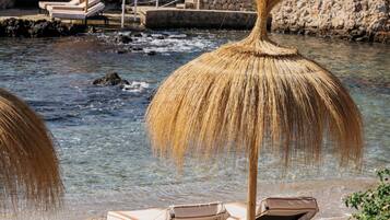 On the beach, white sand, sun loungers, beach umbrellas