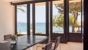 A modern dining area with a view of the sea, large windows, and a table with chairs. - Hotel de Mar Gran Meliá - The Leading Hotels of the World (Calvia)