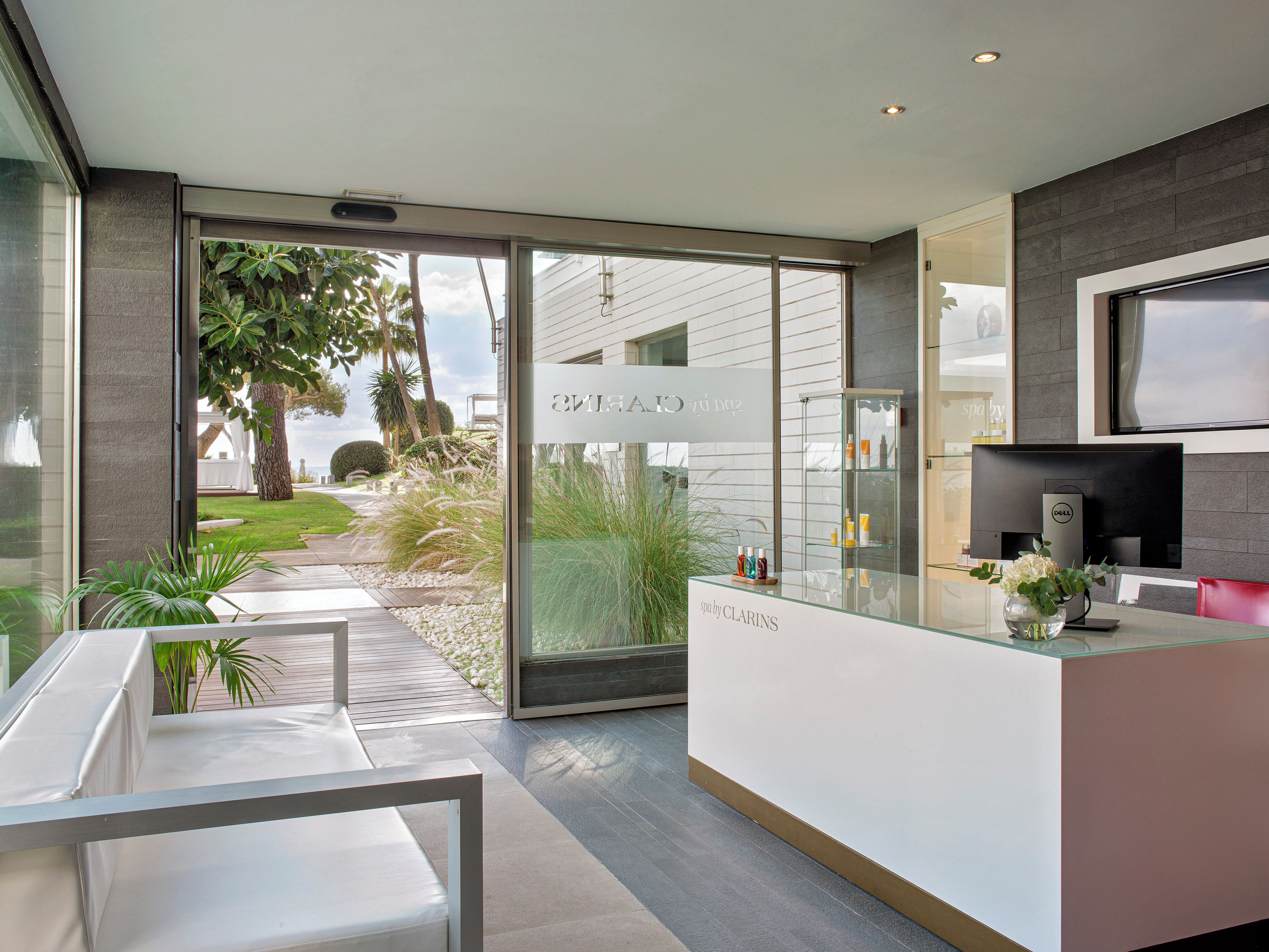 A modern spa with a reception desk, a seating area, and a view of the outdoors.