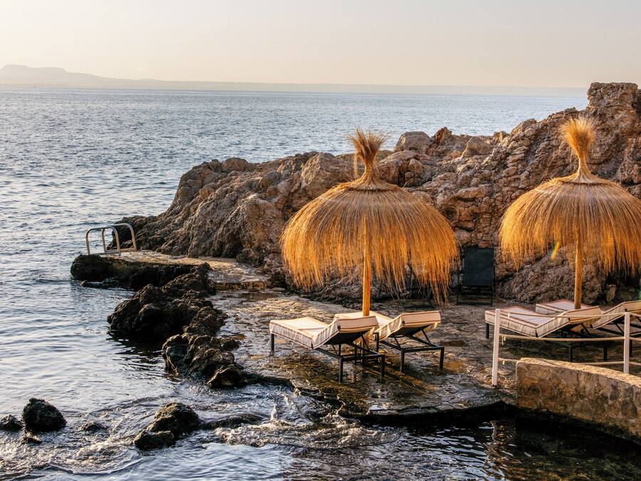 På stranden, hvit sand, solsenger og parasoller