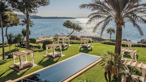 A pool area with a rectangular pool, lounge chairs, and a pergola structure. - Hotel de Mar Gran Meliá - The Leading Hotels of the World (Calvia)