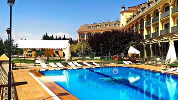 Una piscina al aire libre de temporada, sombrillas