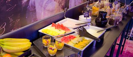 Un bufé con diversas frutas, verduras y bebidas.