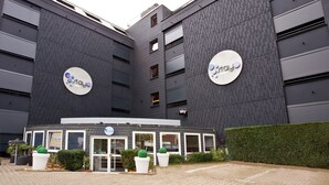 Een modern gebouw met twee grote ronde borden met daarop de tekst ‘stay’ en ‘sky’ op de gevel.