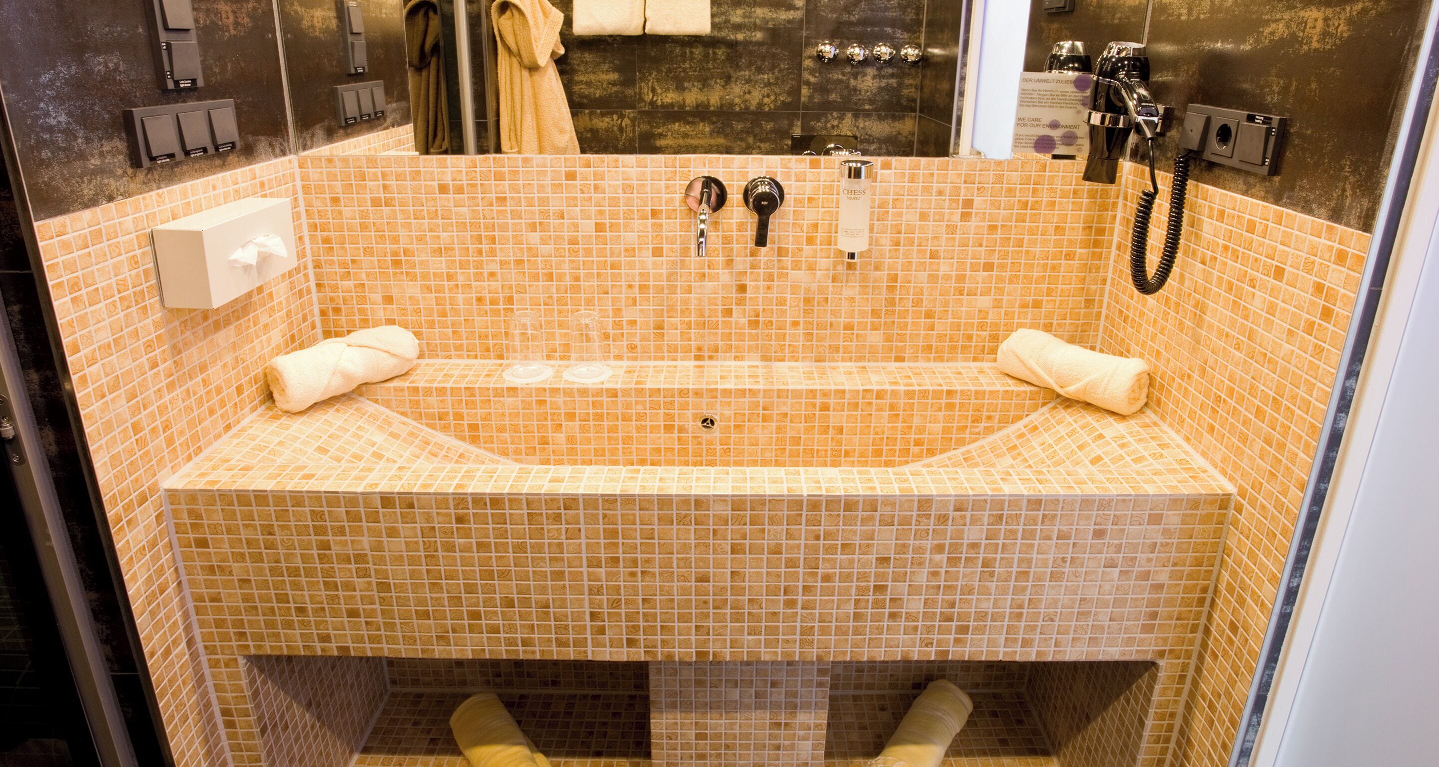 A bathroom with a large bathtub, a towel rack, and a mirror.