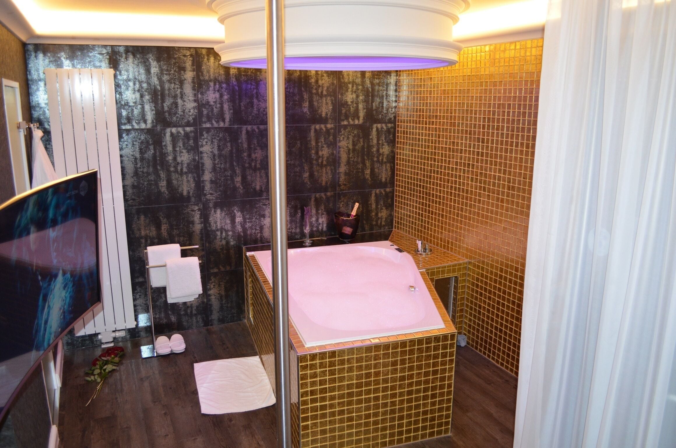 A modern bathroom with a large bathtub, a glass shower enclosure, and a mirror.