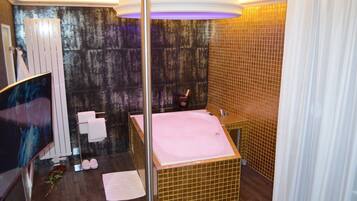 A modern bathroom with a large bathtub, a glass shower enclosure, and a mirror.