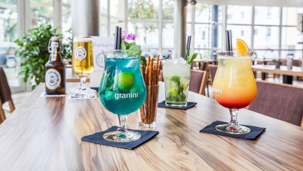 A bar area with various drinks and bottles on a wooden table.