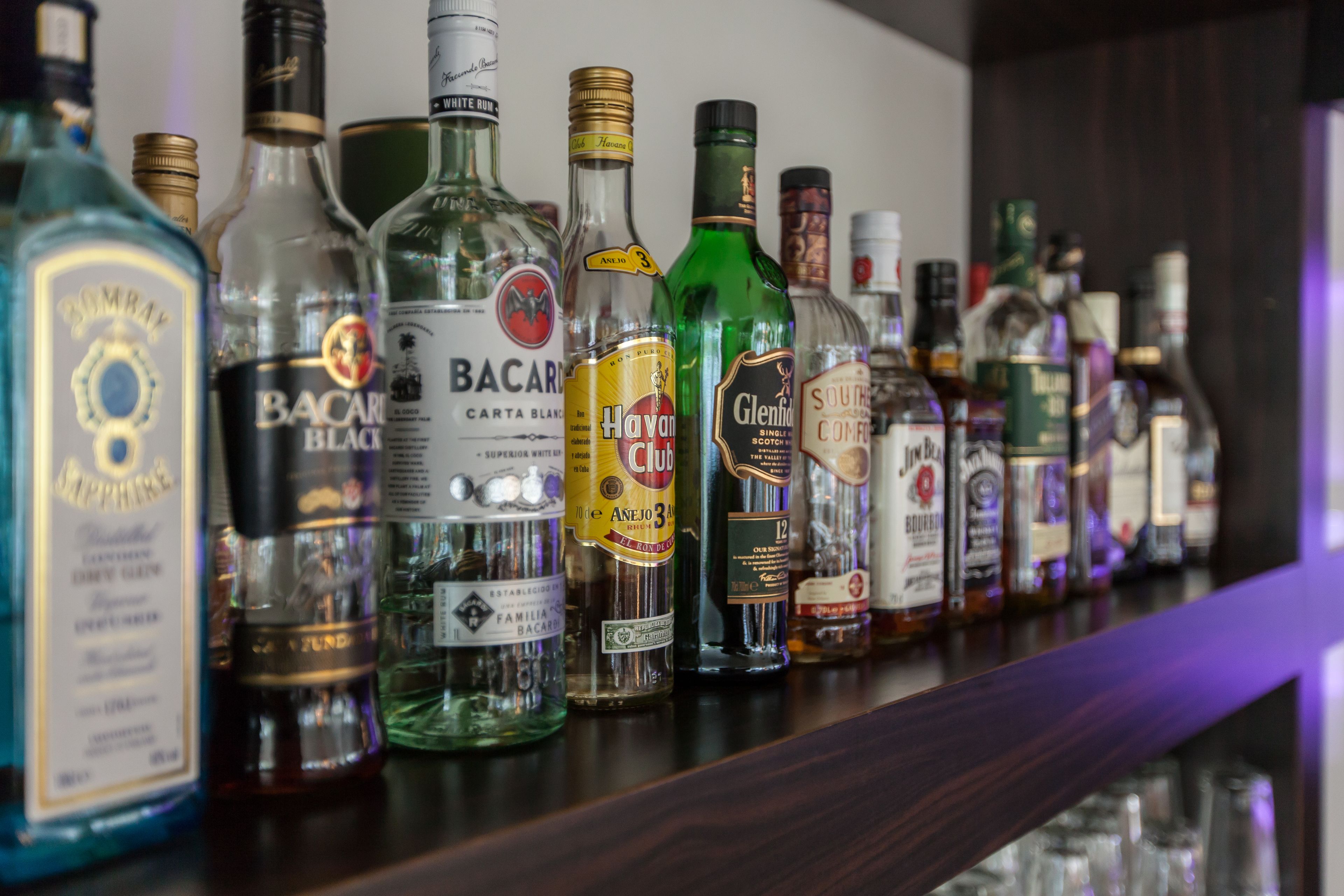 A variety of liquor bottles on a shelf.