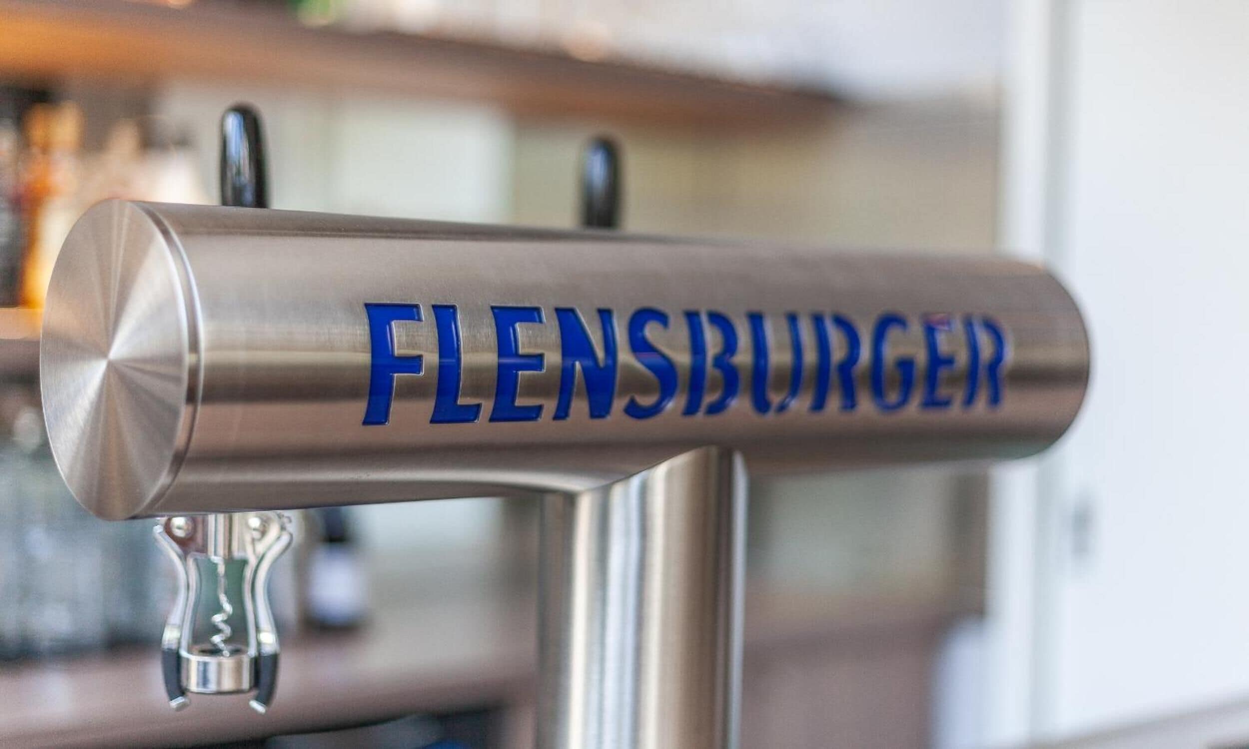 Un grifo de acero inoxidable con la palabra "FLENSBURGER" grabada.