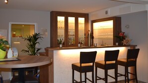 A bar area with a counter, stools, and a glass display cabinet. - Best Western Hotel Erlangen (Erlangen)