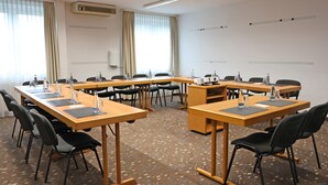 A conference room with a U-shaped table, black chairs, water bottles, and a projector. - Best Western Hotel Erlangen (Erlangen)
