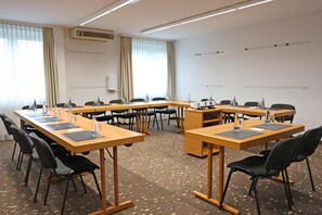 A conference room with a U-shaped table, black chairs, water bottles, and a projector. - Best Western Hotel Erlangen (Erlangen)