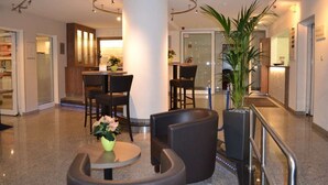 A lobby with a reception desk, seating area, and a large potted plant. - Best Western Hotel Erlangen (Erlangen)