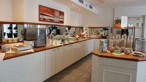 A modern kitchen with a long counter, equipped with a refrigerator, microwave, and various food items. - Best Western Hotel Erlangen (Erlangen)