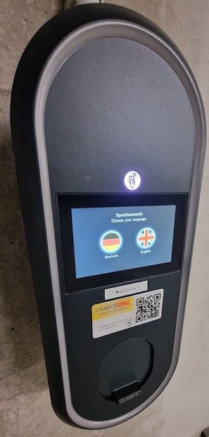 A self-service kiosk with a screen displaying language selection options and a QR code for contactless payment. - Best Western Hotel Erlangen (Erlangen)