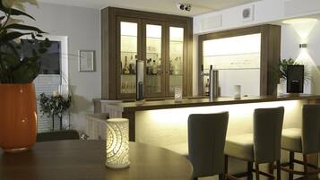 Una cocina moderna con barra, taburetes y una planta decorativa.