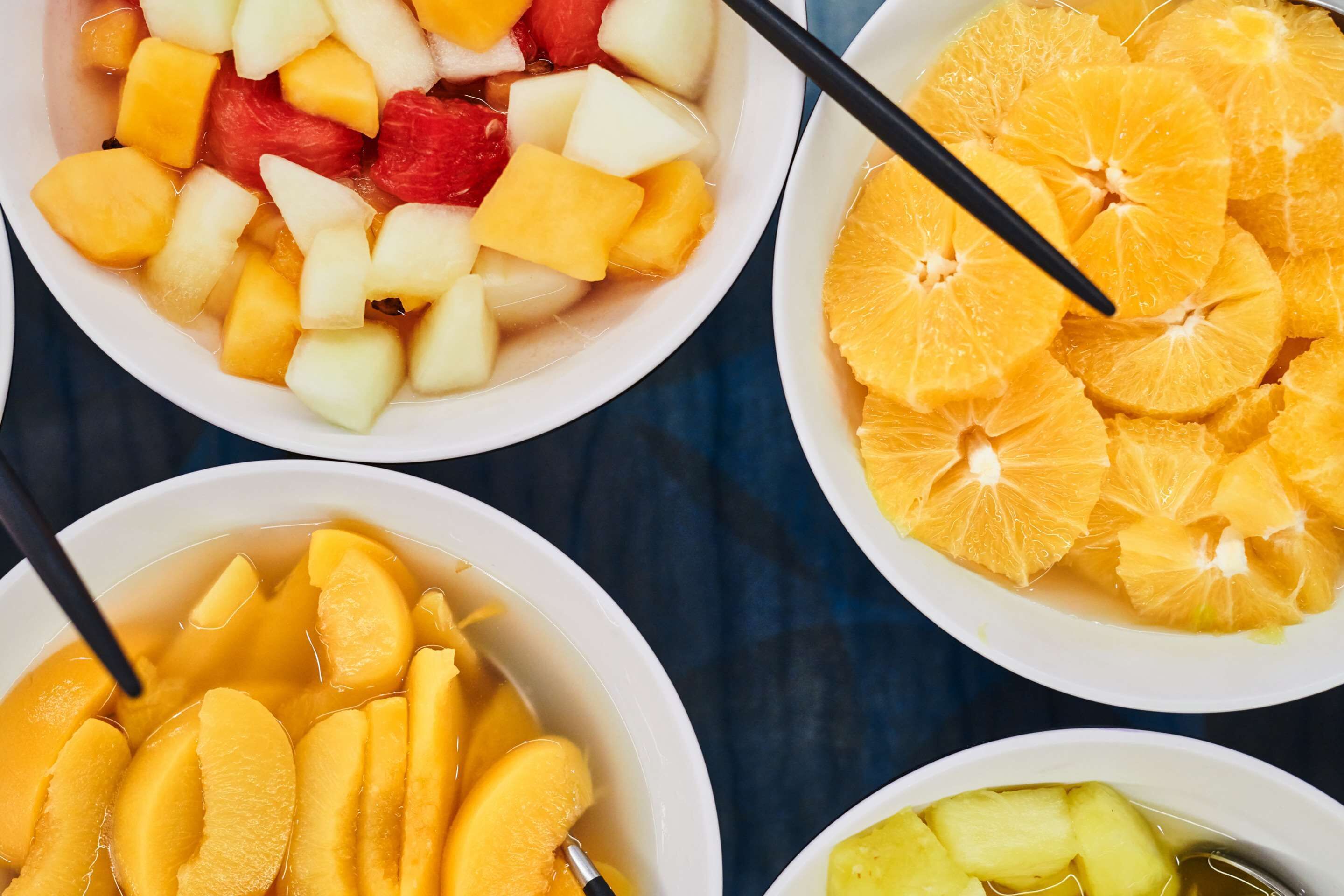 Drei Schüsseln mit Obstsalat, bunt belegt mit verschiedenen Früchten.
