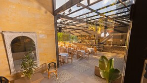 A restaurant with a glass ceiling, wooden furniture, and a fireplace.