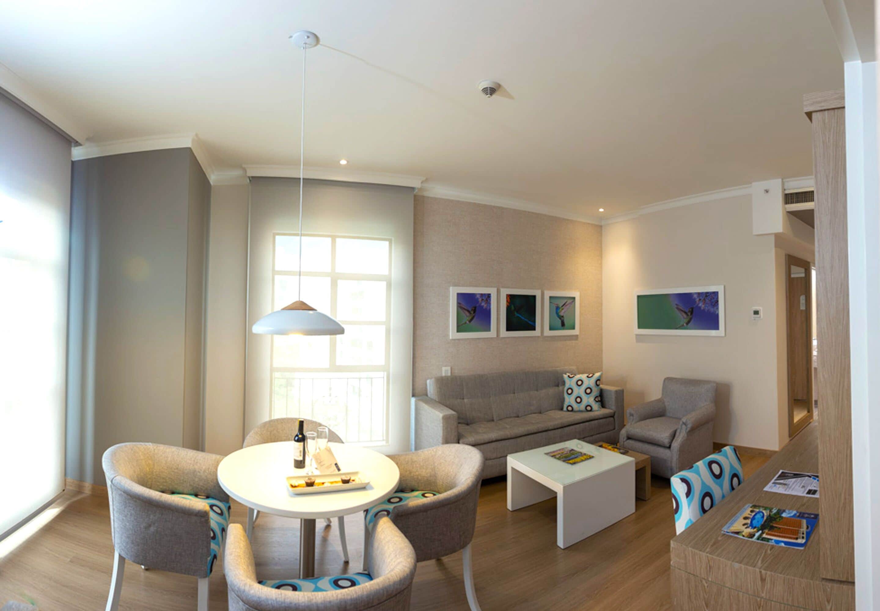 Een moderne woonkamer met een ronde tafel, twee fauteuils, een bank en een salontafel.