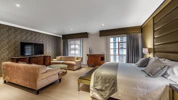 Una habitación de hotel moderna con una cama grande, un sofá, un televisor y un escritorio.
