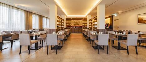 A spacious hotel lobby with multiple seating areas, a central decorative wall, and a well-lit ceiling.