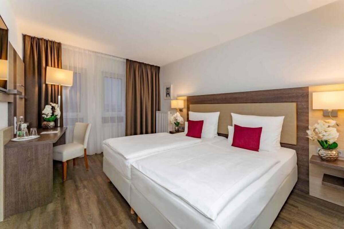 Una habitación de hotel con una cama grande, un escritorio y una silla.