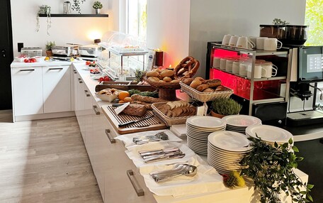 A buffet setup with various food items, plates, and utensils.