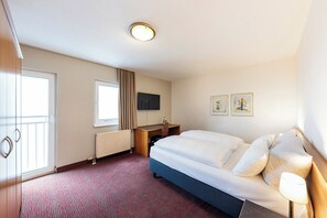 A hotel room with a bed, a desk, a TV, and a window. - ACHAT Hotel Darmstadt Griesheim (Griesheim)