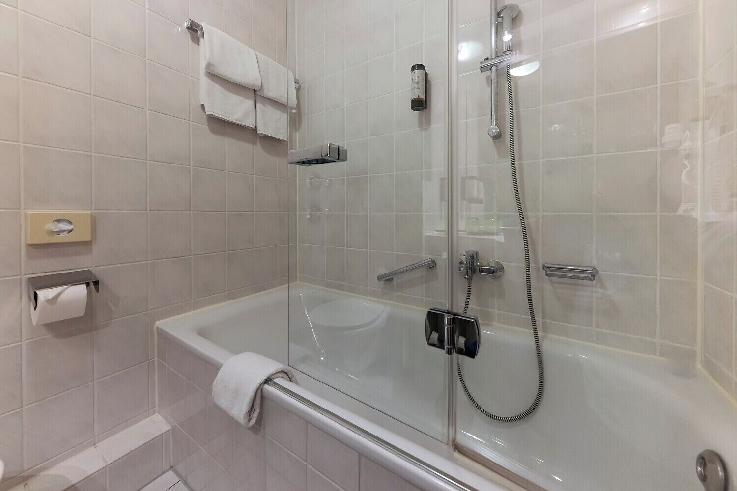 Ein modernes Badezimmer mit einer gläsernen Duschkabine, einer Badewanne und einem WC.